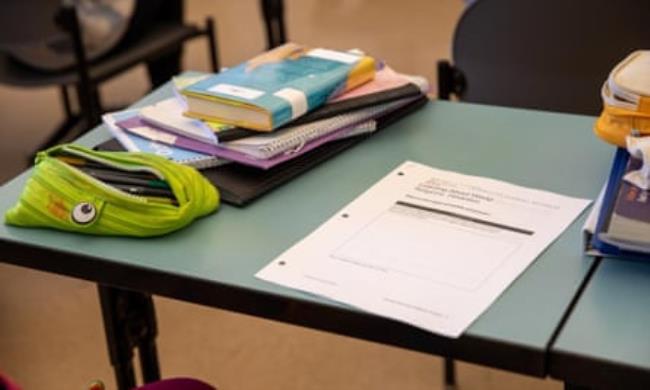 A picture of a school desk with paper on it