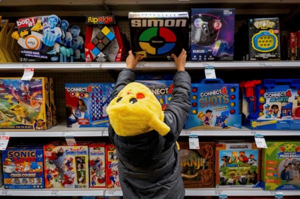 Child wearing Pokemon hat reaching for toy in Target toy aisle.