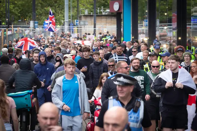 Manchester, UK. 03rd Aug, 2024. Anti-immigration supporters march through the city.