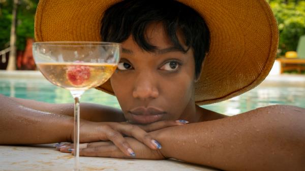 A still from Blink Twice, showing a woman in a pool in front of a cocktail