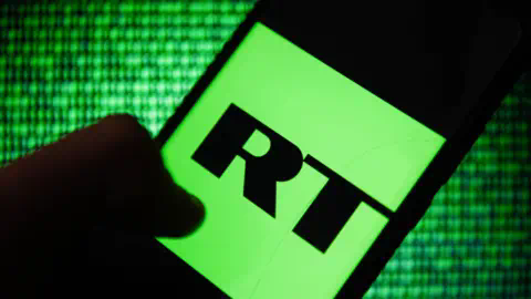 Getty Images RT logo on smartphone on green data background.