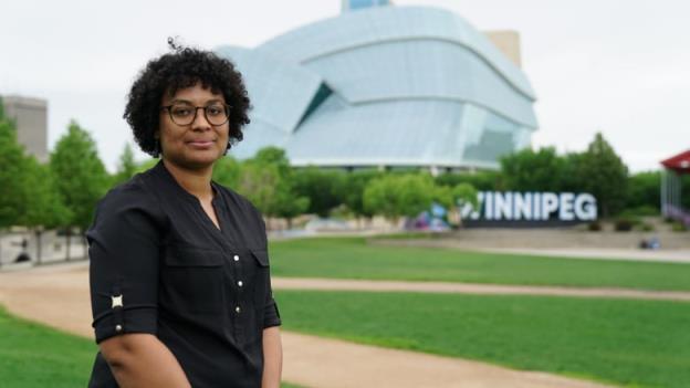 woman stands in front of museum