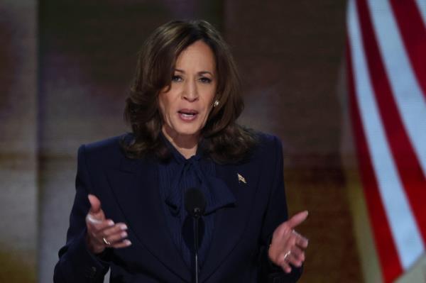 U.S. Vice President Kamala Harris speaking into a microphone at the Democratic National Convention in Chicago, Illinois