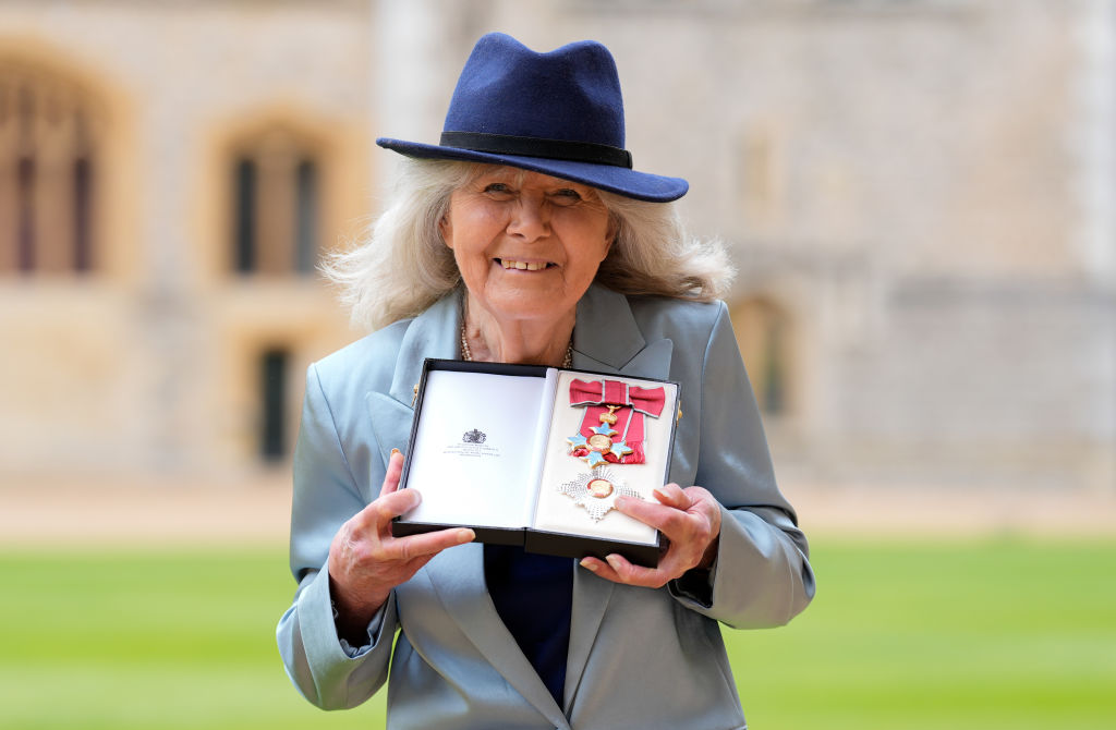 Dame Jilly Cooper - Investitures At Windsor Castle - holds up award to the camera