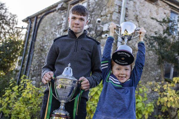 Padraic and Conor Macnamara hold the trophies on behalf of the Macnamara farm. Picture: Clare Keogh