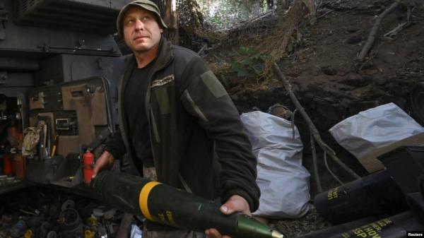 A Ukrainian soldier carries a 155 mm shell before firing toward Russian troops at a front line, amid Russia’s attack on Ukraine, in Kharkiv region, Ukraine Sept. 24, 2024.