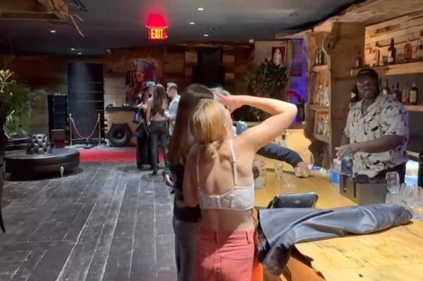 Young women drinking at a long bar.