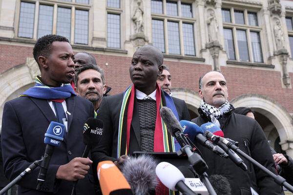 South Africa's Minister of Justice and Correctional Services Ronald Lamola, center, and Palestinian assistant Minister of Multilateral Affairs Ammar Hijazi, right, address the media outside the International Court of Justice in The Hague, Netherlands, Thursday (Picture: AP Photo/Patrick Post)