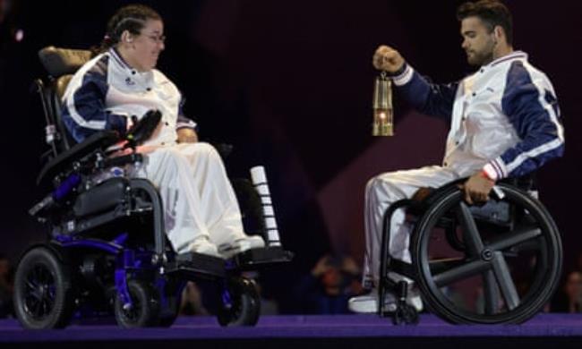 French athlete Mathieu Bosredon brings the Olympic flame next to his compatriot Aurélie Aubert during the Paris 2024 Paralympic Games closing ceremony.