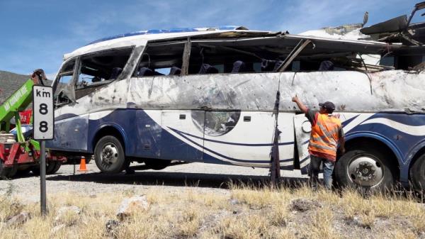 A tow truck moves a bus, on the scene of a road accident.